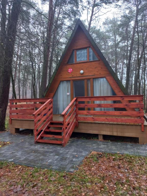 een hut in het bos met een gambrel dak bij Domek w lesie in Bocheniec