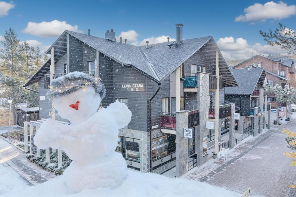 a snowman is standing in front of a building at Lumi City Apartment in Levi