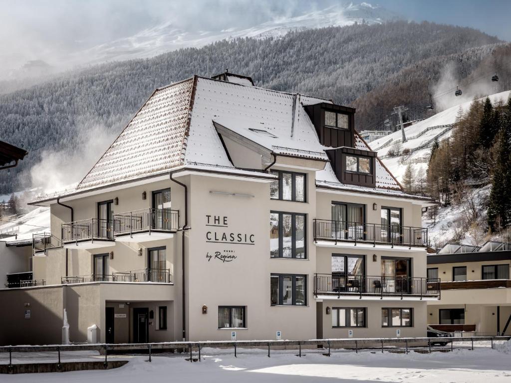un edificio con un cartello sopra nella neve di The Classic by Regina a Sölden