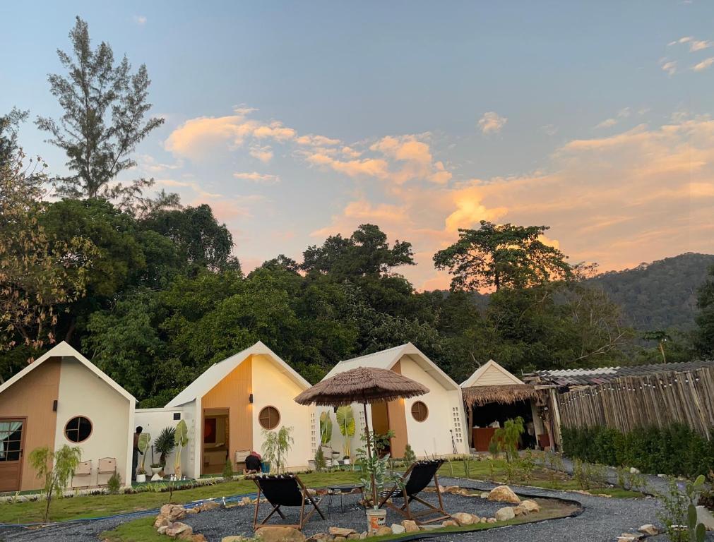 a group of cottages with chairs in a yard at Chamin Longbeach Bungalow in Ko Lanta