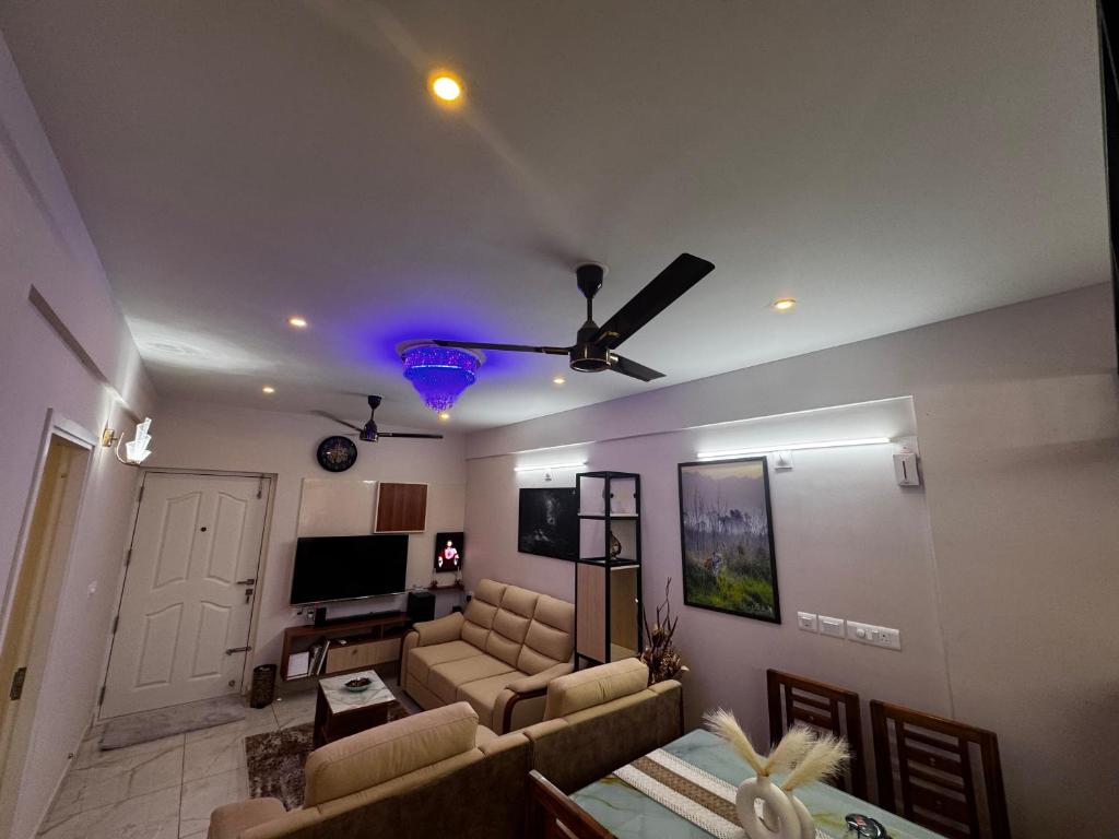 a living room with a couch and a ceiling fan at Zenith apartement in Trivandrum