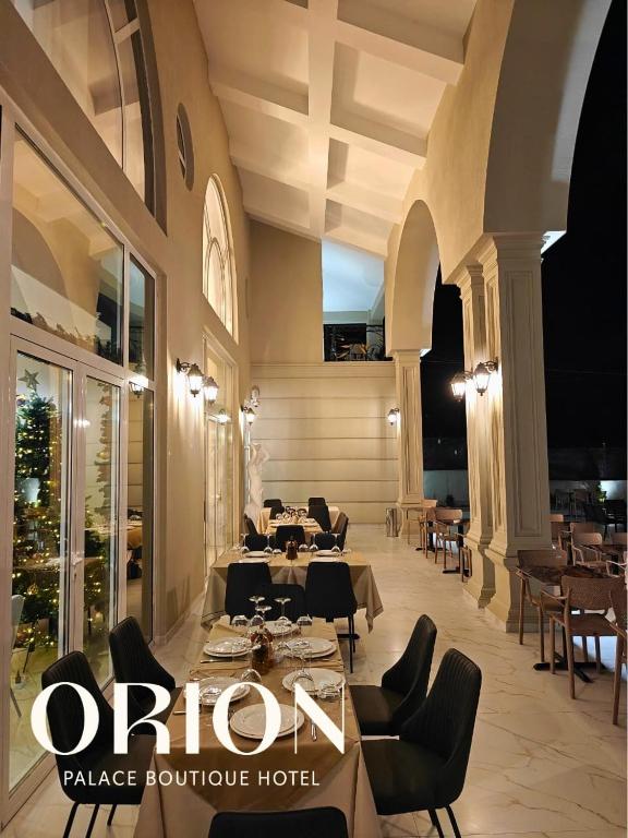 a restaurant with tables and chairs in a building at Orion Palace Boutique Hotel in Durrës