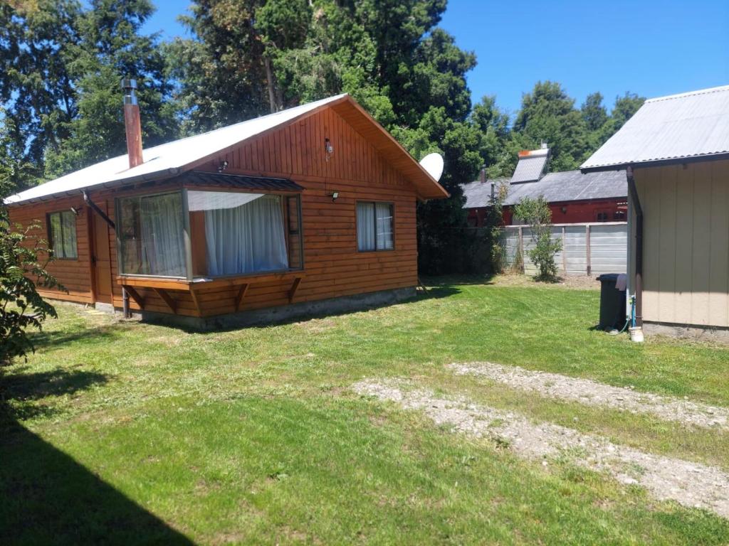 una baita con un cortile accanto a un edificio di cabañas walls 2 a Pucón