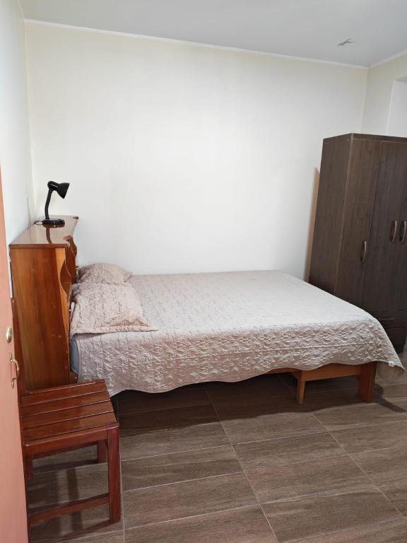 a bedroom with a bed and a wooden cabinet at Habitaciones en la Casa de Dora, 4to y 5to piso in Ayacucho