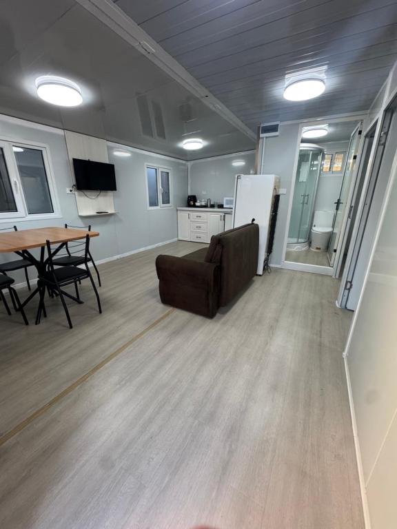 een kamer met een bank, een tafel en een keuken bij Residencial Manhattan in Passo Fundo