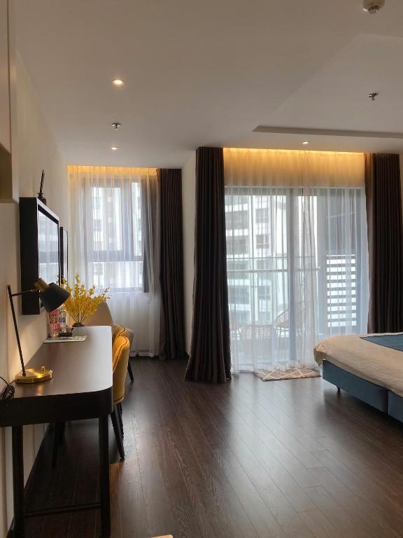 a living room with a bed and a desk in a room at Sapphire Residence Hạ Long in Ha Long