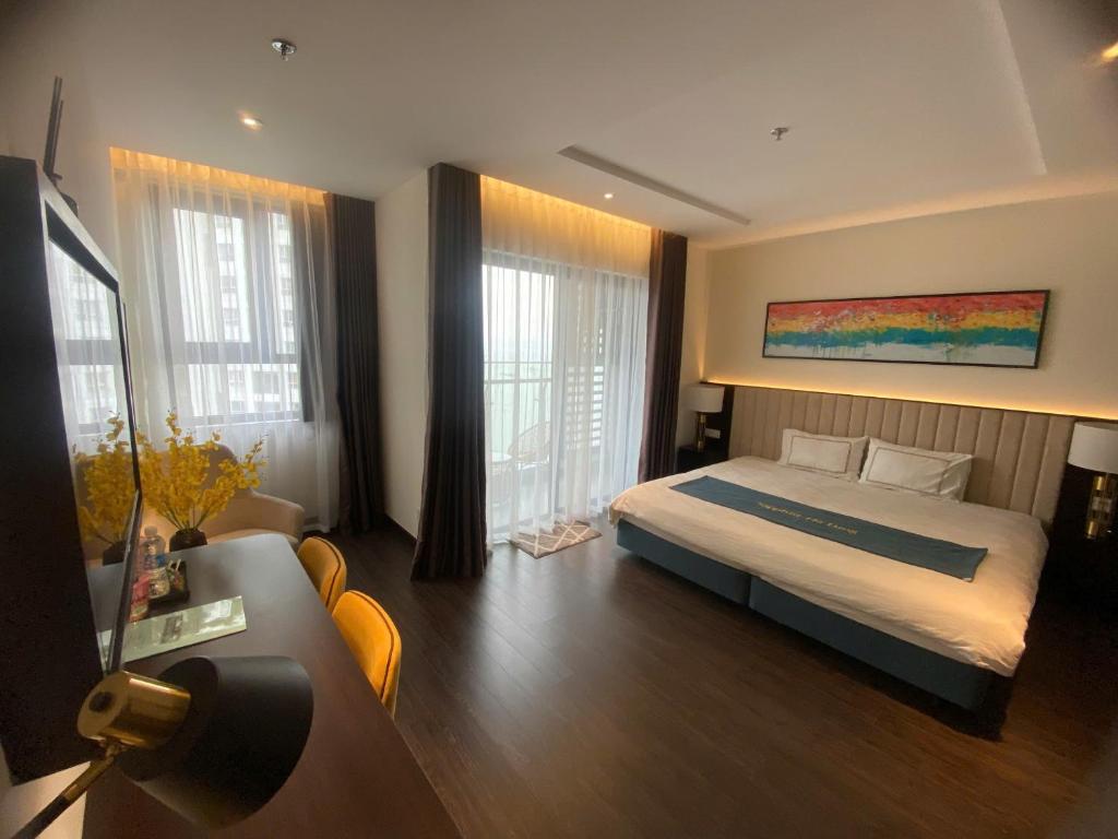 een slaapkamer met een bed en een bank bij Sapphire Residence Hạ Long in Ha Long