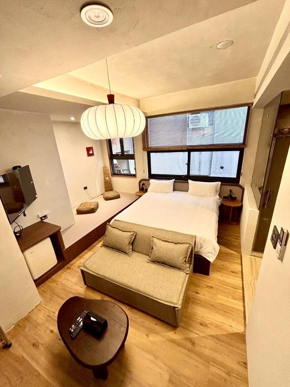 a large bedroom with a bed and a couch at Spring Stay Inn 春眠 不覺曉 in Tainan