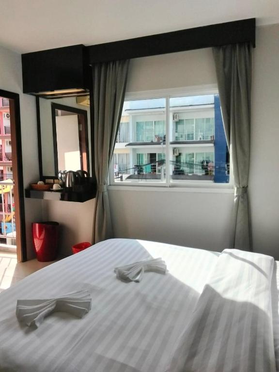 a bedroom with a large white bed with a window at D 1 Hotel in Ban Nong Chaeng
