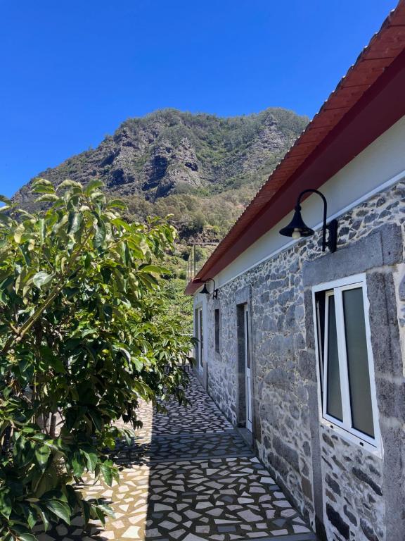 a stone house with a mountain in the background at Casa Duque in Santana with AC and heating in Santana