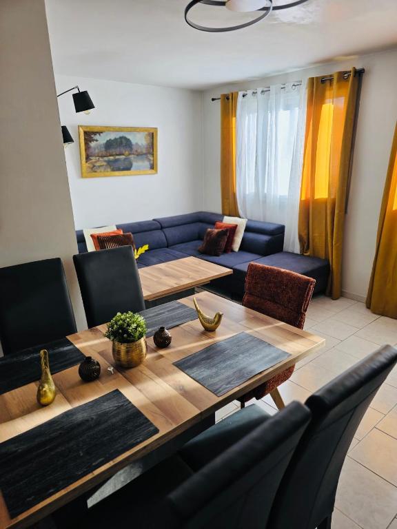 a living room with a table and a blue couch at Le Cocon Bright Large TV Free parking in Fleury-les-Aubrais