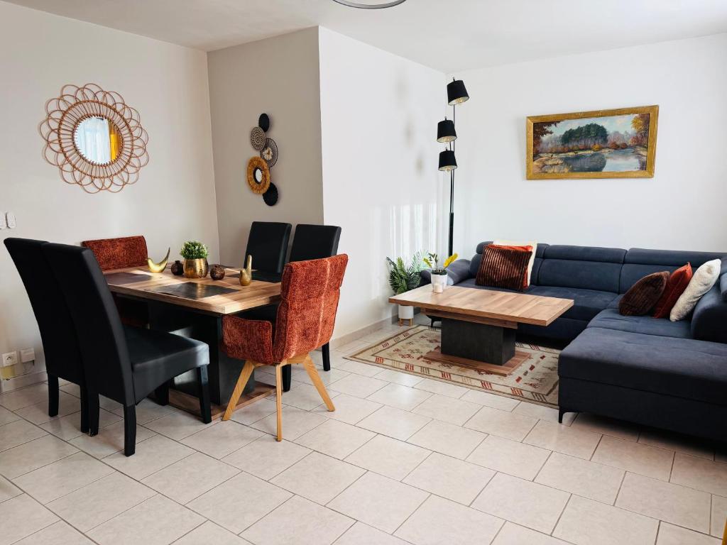 een woonkamer met een tafel en een blauwe bank bij Le Cocon Bright Large TV Free parking in Fleury-les-Aubrais
