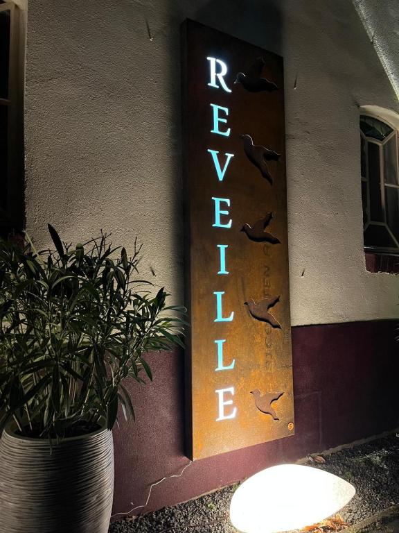 克莱沃B&B Reveille的建筑边有盆栽的标志