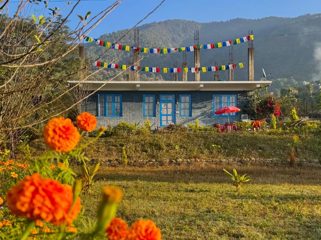 a house on a hill with colorful flags on it at Private Farm Villa With Plunge Pool, Bir Billing - Rishi Casa Blu in Bīr