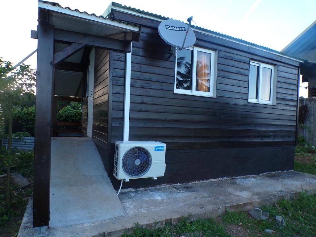 een klein huisje met een luidspreker aan de zijkant bij Bungalow citron in Petit-Bourg
