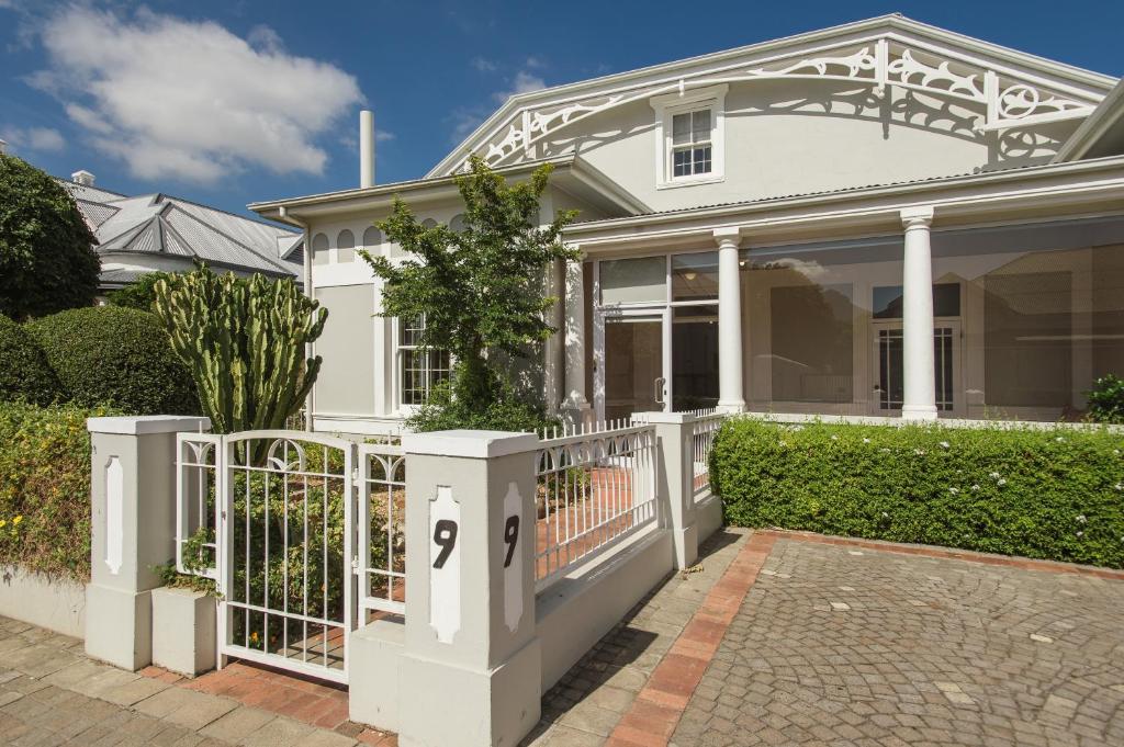 a white house with a gate in front of it at Story Haus in Stellenbosch