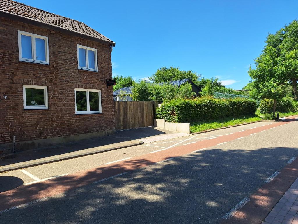 a brick house on a street with a tree at Beutenaken Drie in Beutenaken