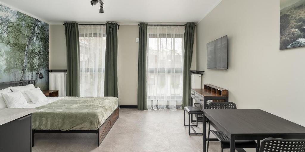 una camera da letto con un letto, un tavolo e delle sedie di Praga Studio Apartments a Varsavia