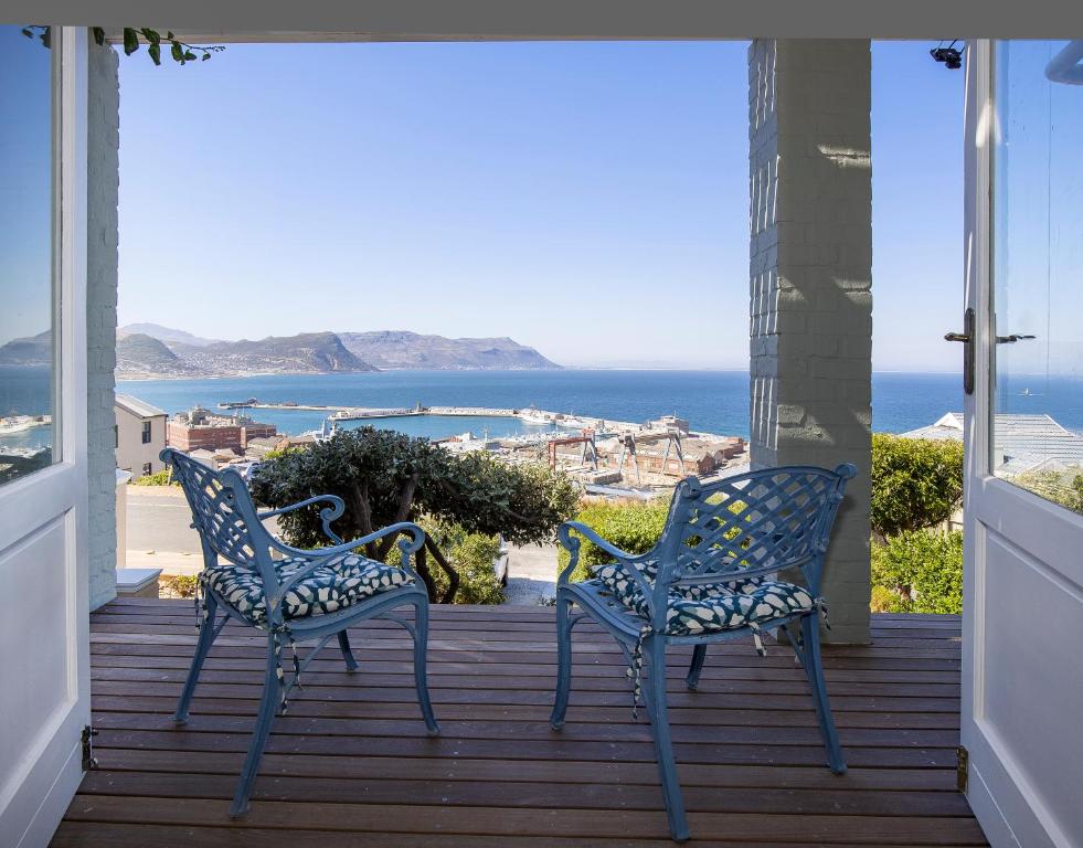 zwei Stühle auf einer Veranda mit Blick auf das Meer in der Unterkunft LIMA HOUSE, Seaforth, Simon's Town in Simonʼs Town