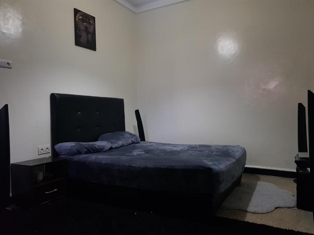 een slaapkamer met een bed en een tv erin bij Atlas Agdal Apartment in Rabat