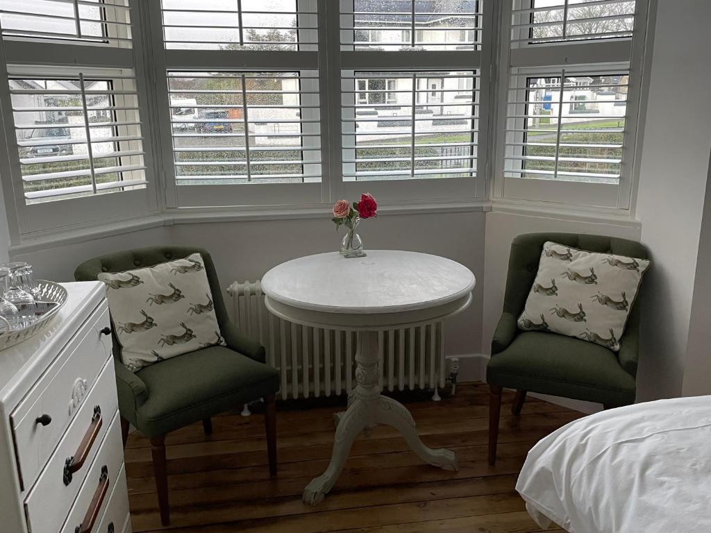 a bedroom with a table and two chairs and a bed at 7 Goathill Crescent in Stornoway