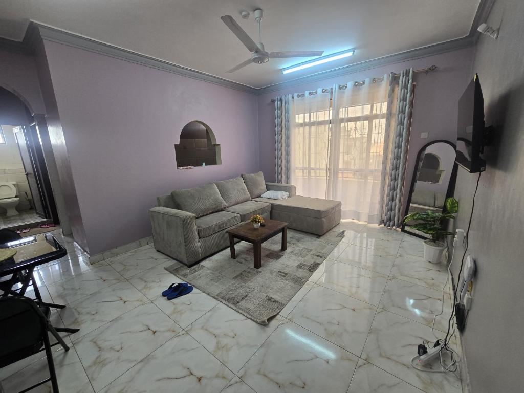 a living room with a couch and a table at Flynn Stays in Bamburi