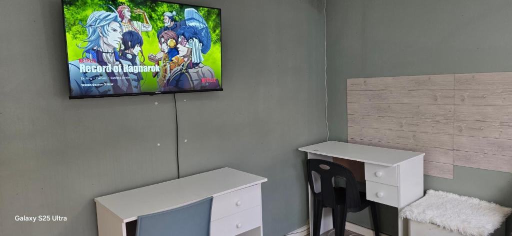 una TV appesa a una parete in un soggiorno di Station Home a Città del Capo