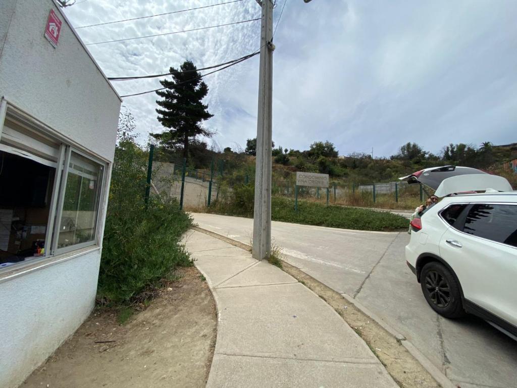 een witte auto geparkeerd aan de kant van een straat bij Viña Oriente in Viña del Mar