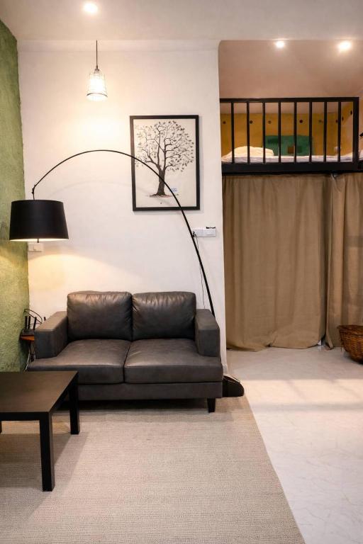 a living room with a couch and a lamp at Earth House HomeStay Bangjo in Ban Pak Lak