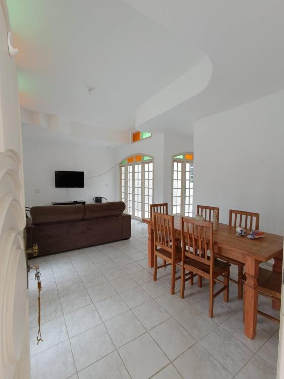 a living room with a table and chairs and a couch at Casa Duque Peruíbe in Peruíbe
