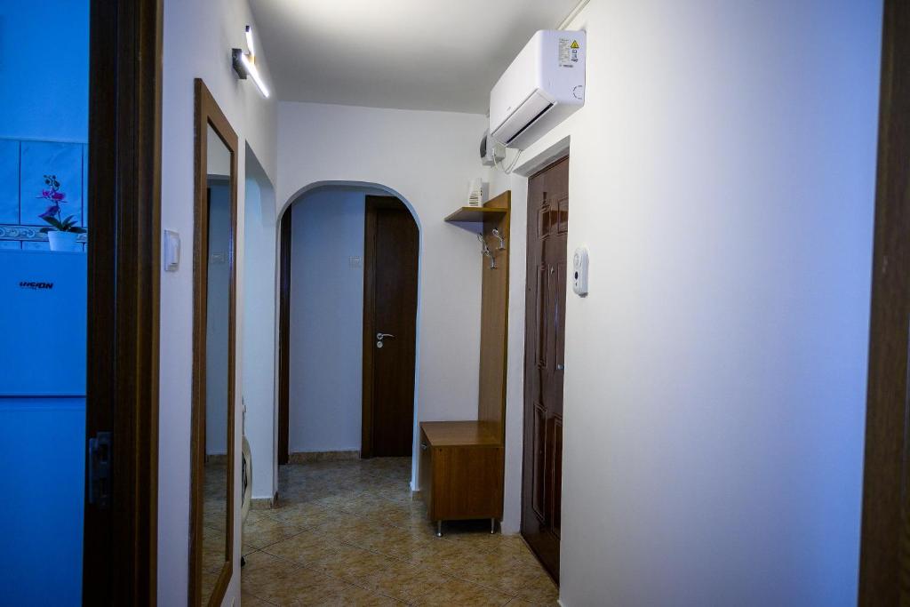 a hallway with a white wall and a hallway with two doors at House Dey in Făgăraş