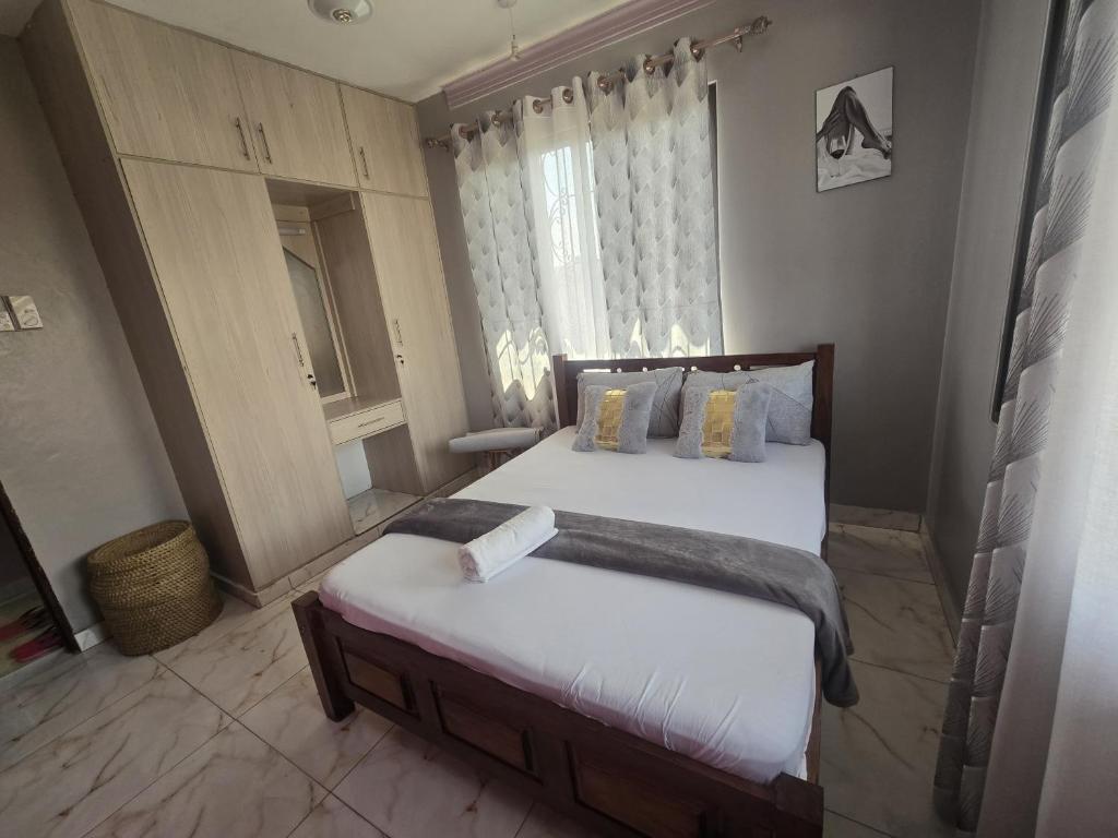 een slaapkamer met een groot bed en een raam bij Flynn Stays in Bamburi