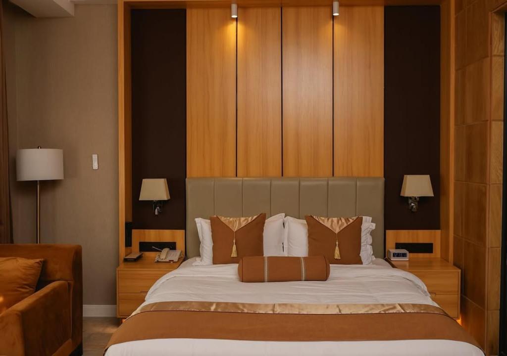 una camera da letto con un letto grande con armadi in legno di Atlantiis Suites Inn Mahmoorganj Near Vishwanath Temple a Varanasi