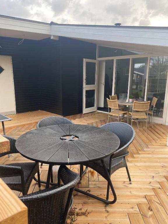 a patio with a table and chairs on a deck at Glentevej idyl in Assens