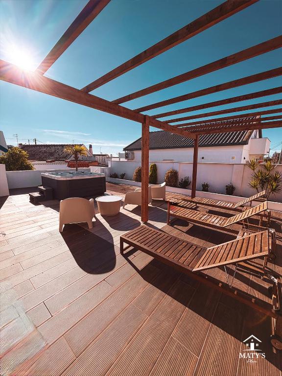a patio with a wooden deck with a table and chairs at Maty's Place in Mafra