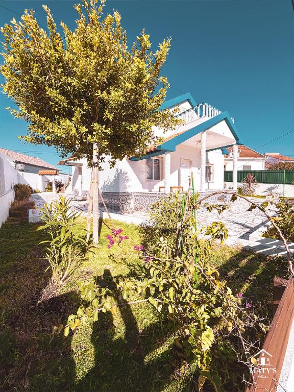 a garden with a tree and flowers in a yard at Maty's Place in Mafra
