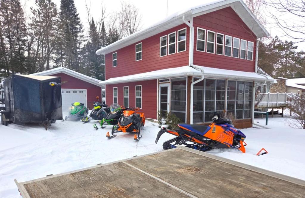 drie motoren geparkeerd voor een rood huis bij Red Arbor Retreat in Arbor Vitae WI in Arbor Vitae