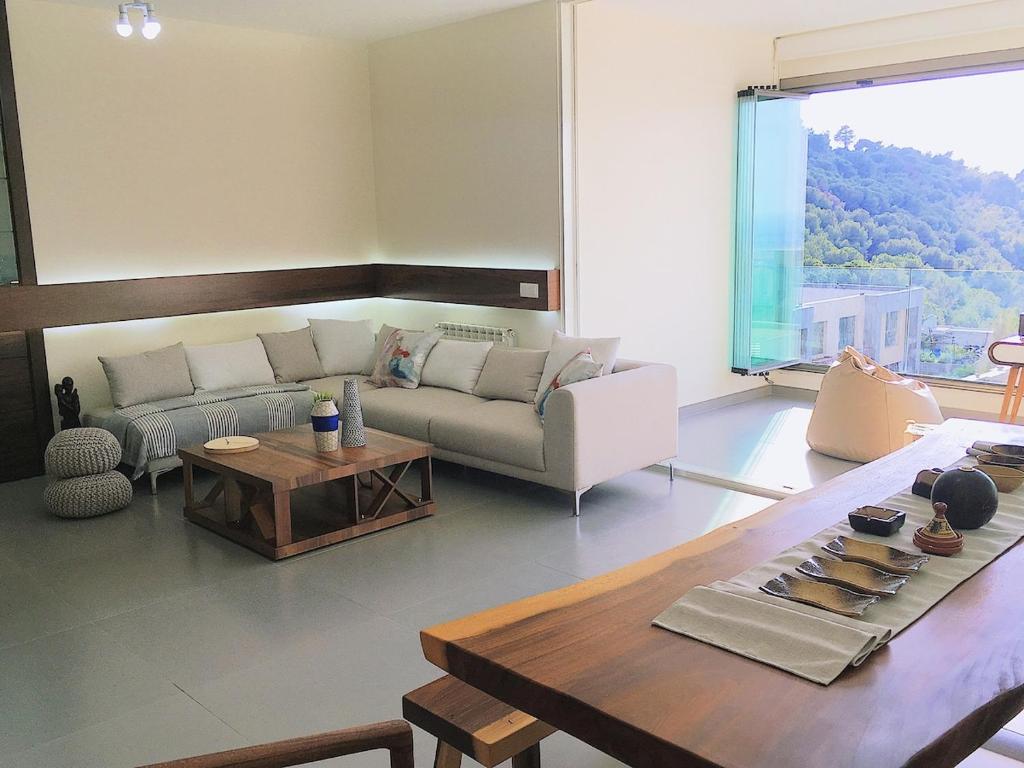 a living room with a couch and a table at Lucas Apart 2Bdr & 2Bth with pool in Mār Yūsuf