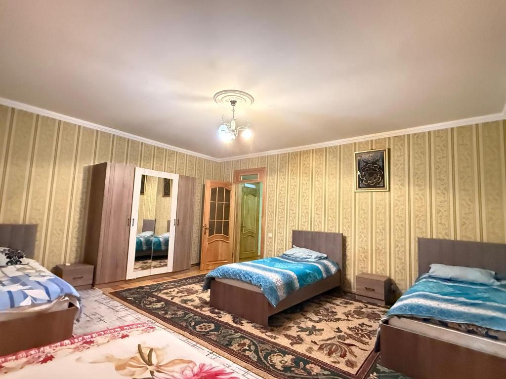 a bedroom with two beds and a mirror at Heaven apartment in Gabala