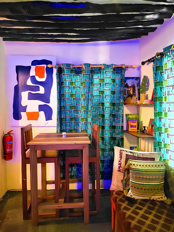 a dining room with a wooden table and a couch at Four Seasons in Stone Town