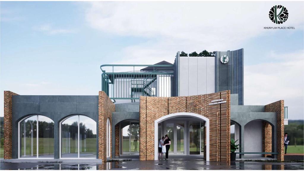 una persona in piedi di fronte a un edificio di KYP Hotel โรงแรมขุนยูวเพลส a Fang