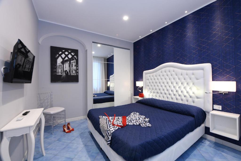ein blau-weißes Schlafzimmer mit einem Bett und einem TV in der Unterkunft Appartamenti Amalfi Centro Storico in Amalfi