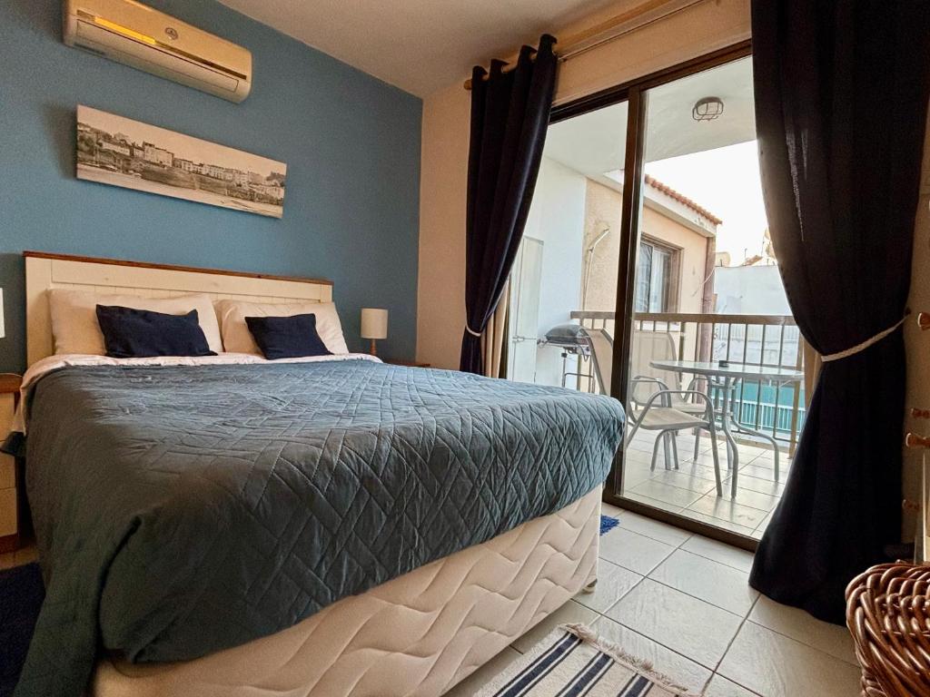una camera da letto con un letto e un balcone con un tavolo di Kapparis Beach Escape a Paralimni