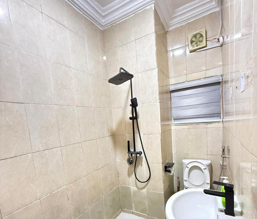 ein Bad mit Dusche, WC und Duschkopf in der Unterkunft Lively Maitama in Abuja