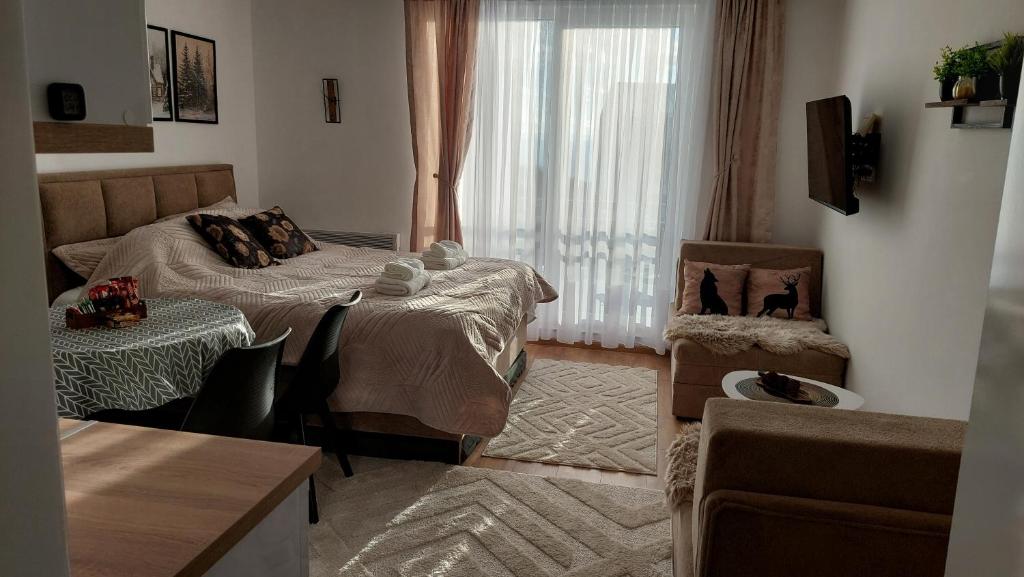 a living room with a bed and a window at Kopaonik Alibi25 in Kopaonik
