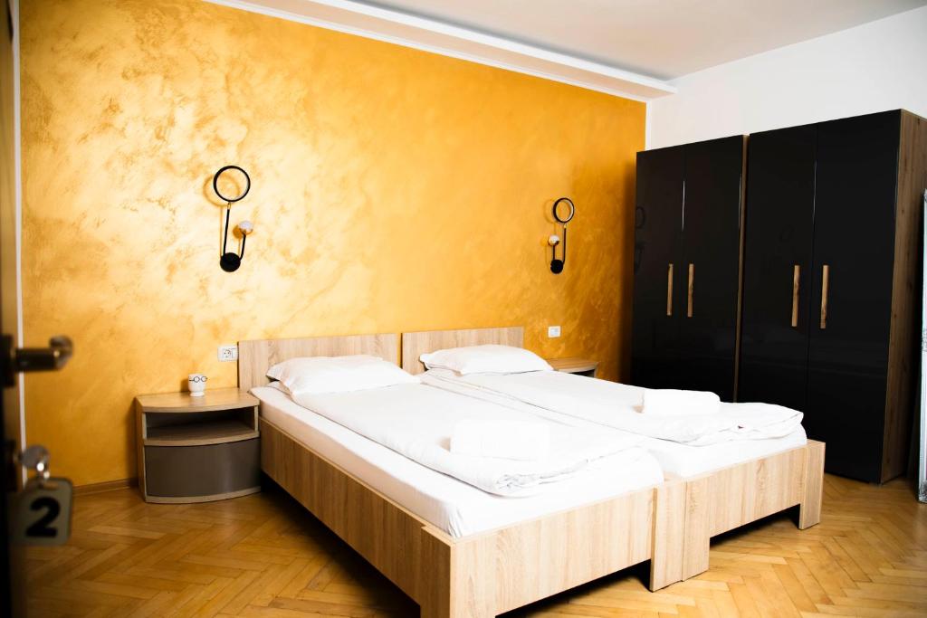 una camera con un grande letto e una parete gialla di Random House a Braşov
