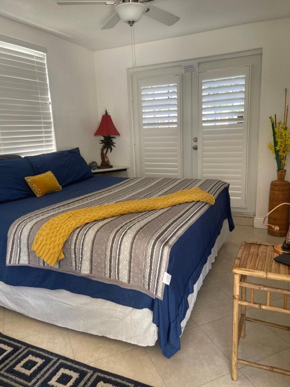 a bedroom with a bed with a yellow and blue blanket at Stunning suite by hard rock stadium and casino in Miami