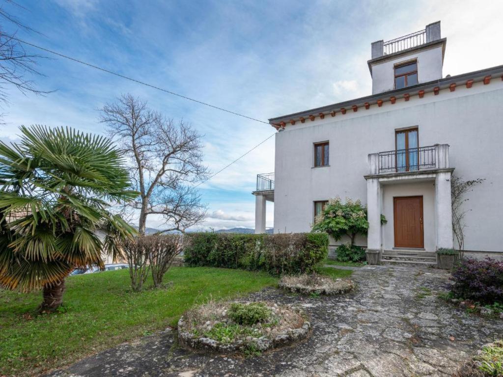 ein weißes Haus mit einer Palme davor in der Unterkunft Villa Maria in Castelletto Soprano