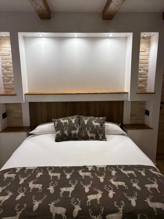 a bedroom with a bed with a black and white blanket at B&B Dimora della Fonte in Roccaraso