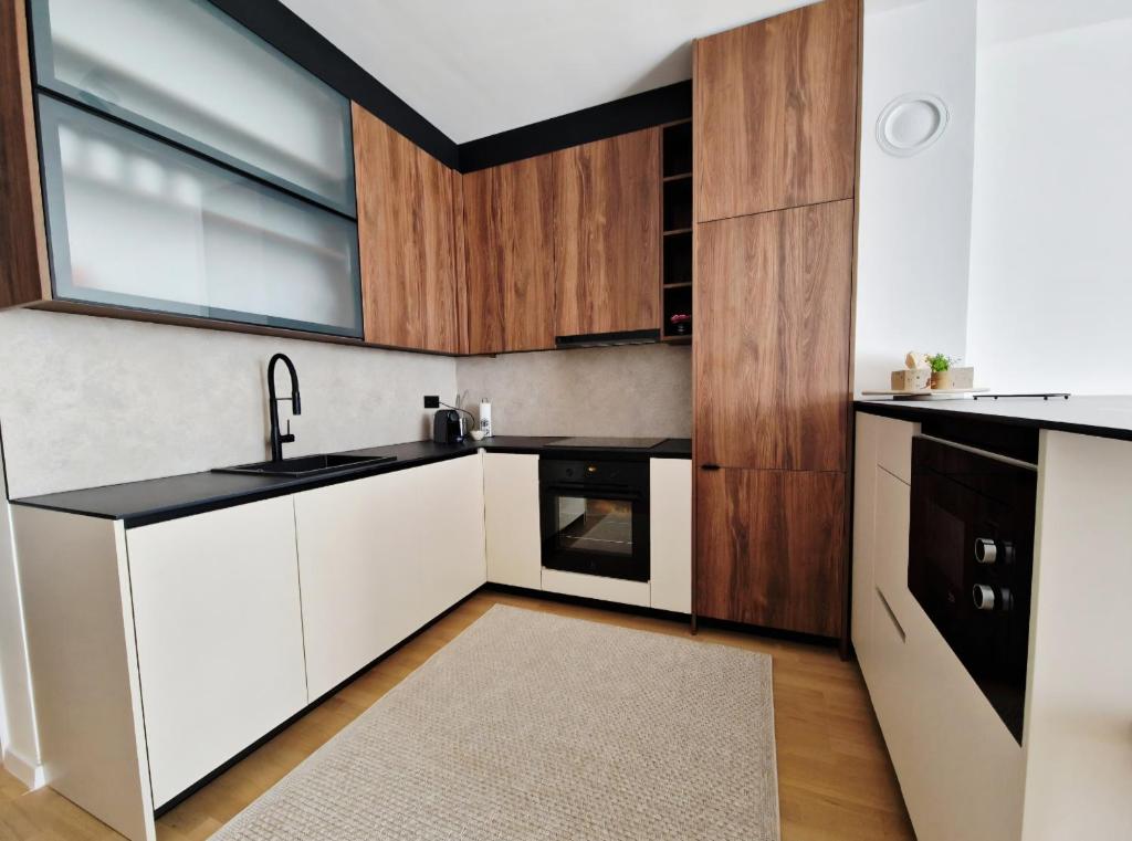 eine Küche mit weißen Schränken und einem Fenster in der Unterkunft Infinity Apartment & Privat Garage in Sarajevo
